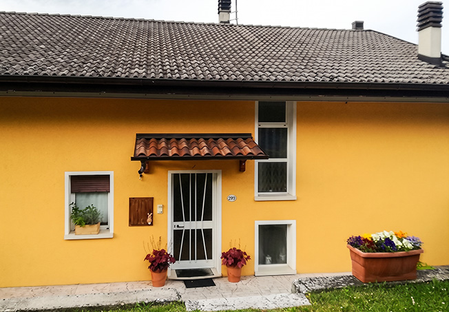 Esterno di una casa singola con impianto a pompa di calore AQUA Clivet e fotovoltaico per l'acqua calda.